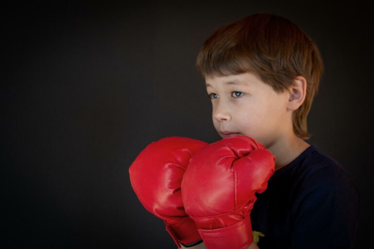 Enfant avec des gants de boxe rouges découvrant la boxe éducative à Albi